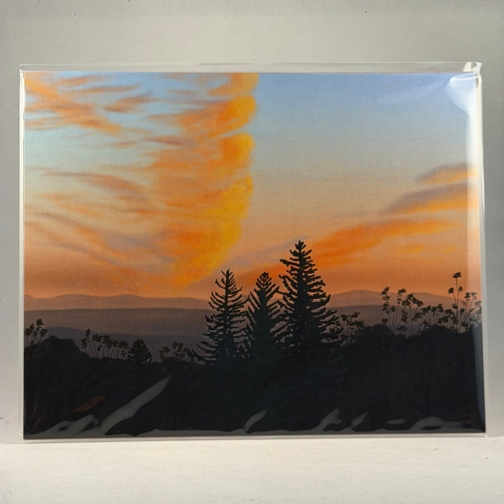 A 8x10 art print depicting a sunrise landscape with dark tree silhouettes against a sky that transitions from blue to orange and yellow, photographed against a light neutral background.