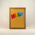 A boxed notecard set with a windowed kraft brown box, featuring a yellow and white vertical striped card with the word 'HELLO' in bright rainbow colors set against the background near the top of the card. 