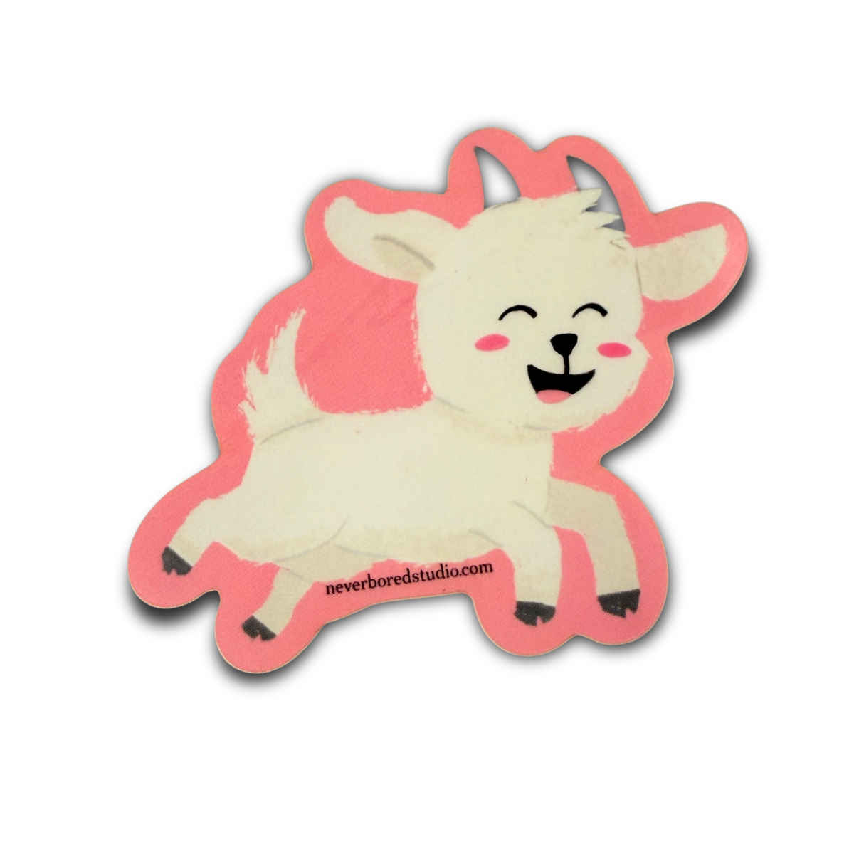 A die-cut sticker featuring a cartoon white goat with a pink outline, closed eyes and mouth, and pink cheeks. 